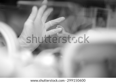 A tiny baby hand catching a doctor's little finger