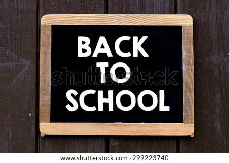 Back to school Sign on blackboard on wooden background
