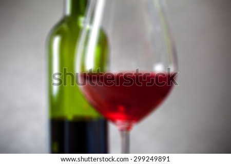 red wine in goblets and green bottle. romantic blur still life