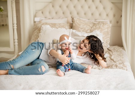 Mom with a baby daughter, laughing and hugging, happy family