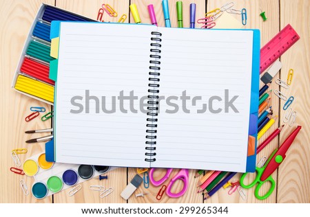 Notebook with school supplies on a wooden background Royalty-Free Stock Photo #299265344