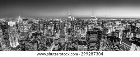 New York City. Manhattan downtown skyline with illuminated Empire State Building and skyscrapers at dusk seen from observation deck. Panoramic view. Black and white photo.