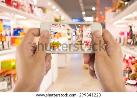 Taking picture with mobile, smart phone in shopping mall.