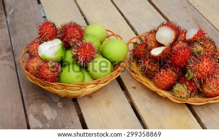 Red rambutan Nephelium lappaceum on broun board. Fruit tropical tree of the family Sapindaceae , native to South - East Asia , cultivated in many countries in the region