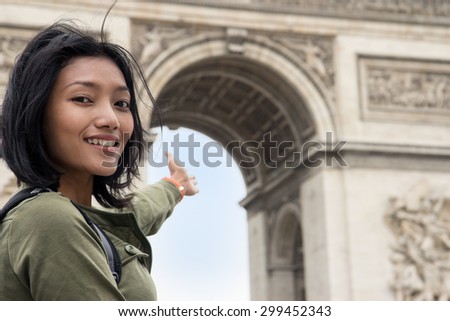 woman pointing at the Triumphal Arch - arc de Triomphe