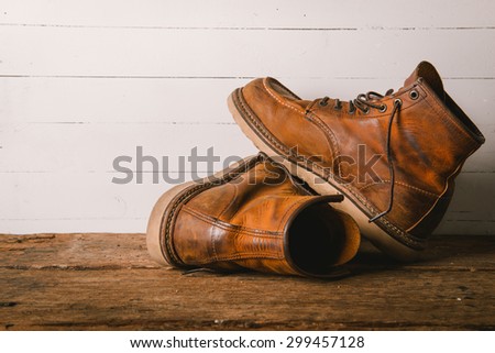 Old leather boot traditional leather style on wooden background with filter vintage style effect