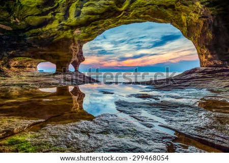 The sun sets on Lake Superior as photographed from a sea cave on a stretch of rocky coast in Michigan's Upper Peninsula.