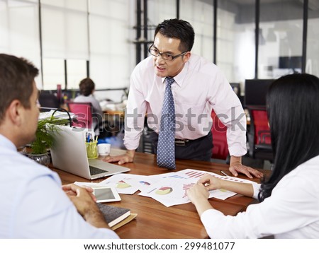 bad-tempered asian businessman yelling at two subordinates in office. Royalty-Free Stock Photo #299481077