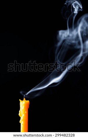 extinguished candle yellow with smoke, isolated over black