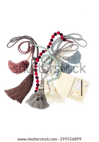 Group of curtain ties on table with pencil and notebook