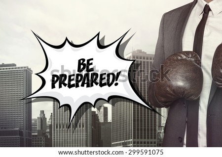 Be prepared text with businessman wearing boxing gloves on cityscape background