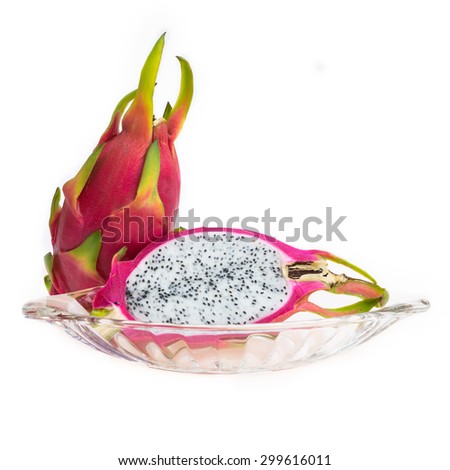 A dragon fruit and the other half in clear plate on white