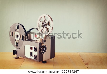 old 8mm Film Projector over wooden table and textured background
