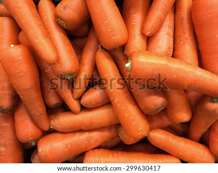 pile of department store carrot. Pile of well cleaned beheaded-off raw carrot ready for customer to pick in retail supermarket. Royalty-Free Stock Photo #299630417
