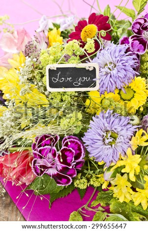 a bouquet of flowers with a tag saying: "Love you"