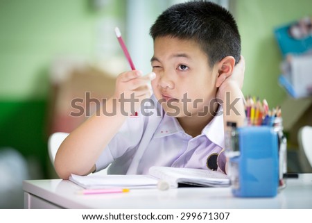 Young asian boy doing his homework at home