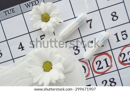 Woman hygiene protection, close-up.menstruation calendar with cotton tampons,daisy