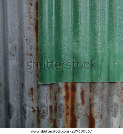 Old rusted corrugated zinc sheets overlapping to form a wall