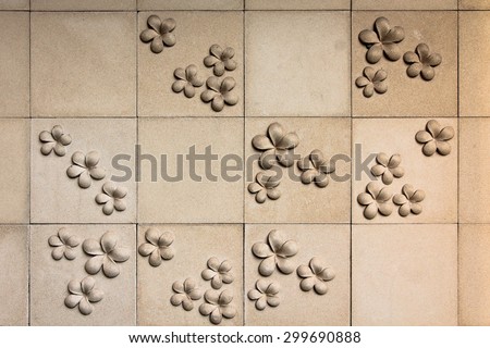 Stone flowers on old cement wall ,Frangipani flowers
