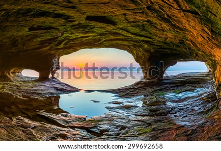 The setting sun, reflected upon the chilly waters of Lake Superior, is viewed from a sea cave along the Upper Peninsula coast of northern Michigan.