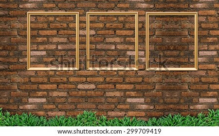 blank golden picture frame on the old brick wall and green grass, background