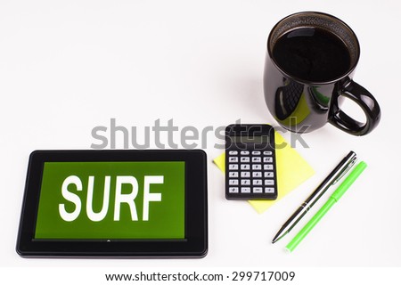 Business Term / Business Phrase on Tablet PC - Cup of coffee, Pens, Calculator and a green/yellow note pad on a White surface - White Word(s) on a green background - Surf