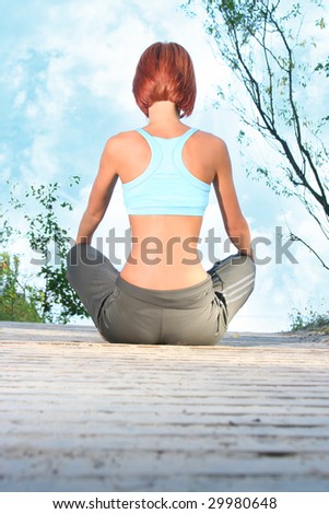 young girl meditating on beach