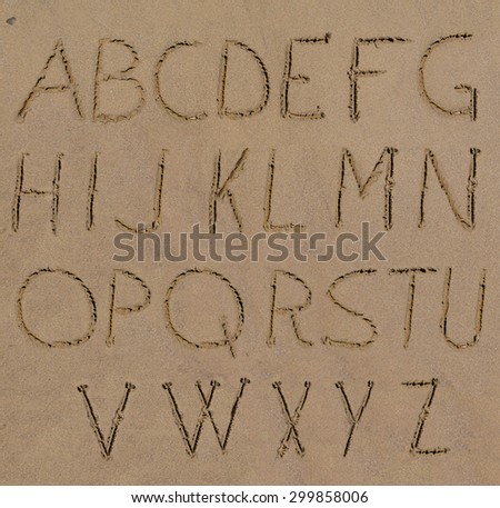 Sand alphabet letters handwritten on beach Royalty-Free Stock Photo #299858006