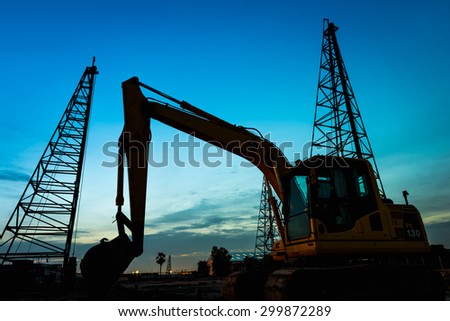Silhouette photo in construction site . The dark shape and outline of construction machine a lighter background, especially in dim light.