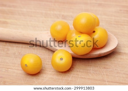 yellow cherry tomatoes over wooden background