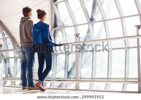 couple holding hands and waiting at airport terminal