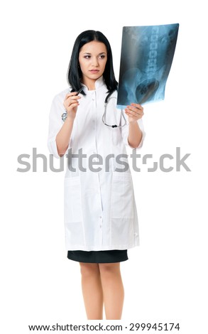 Young female doctor looking at the x-ray picture, isolated on white background 