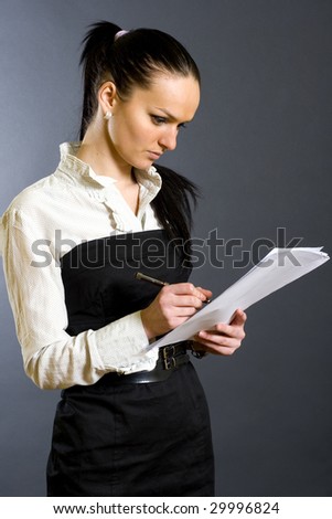 attractive businesswoman signing papers
