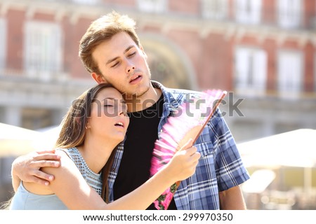 Couple suffering summer heat and fanning with a fan