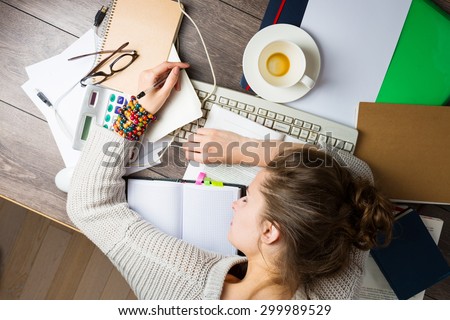 tired student girl with books and coffee sleeping on the table. education, session, exams and school concept . studying hard. Top view Royalty-Free Stock Photo #299989529