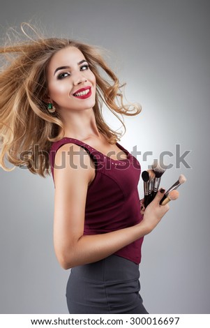 beautiful woman is a master of makeup, shot on a gray background