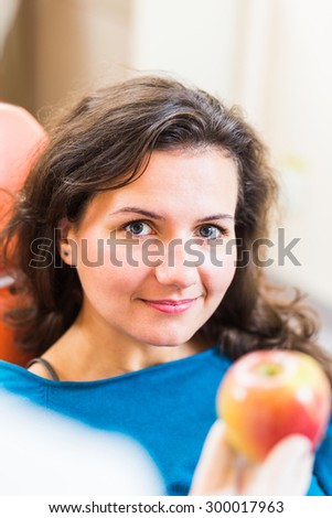Doctor  gives to his patient sitting in a chair an  apple