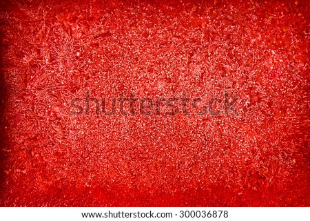 Mashed red fresh frozen strawberries, white frost, red background