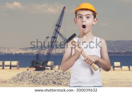 Cute little boy as a construction worker on a industrial background. Image with shallow depth of field.