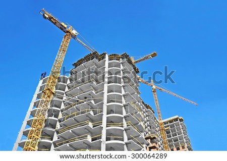 Crane and building construction site against blue sky Royalty-Free Stock Photo #300064289