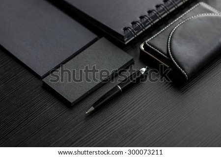 Set of black mockups on dark background,  female hand holding a business card