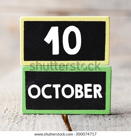 10 october on blackboards on wooden background