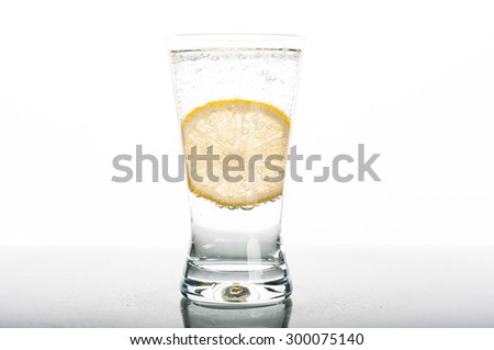 Photo of glass of water with lemon slice on white background