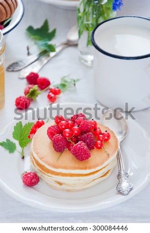 Pancakes with raspberries, red currant and honey