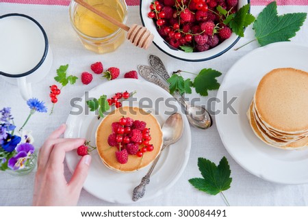 Breakfast Pancakes with raspberries, red currant and honey
