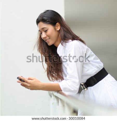 A pretty girl takes a rest while sending message through hand phone