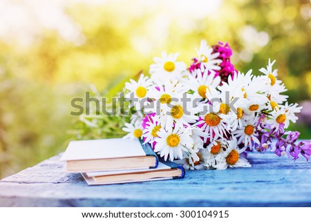 Vintage books with bouquet of field flowers/ nostalgic summer background