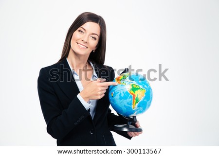 Smiling businesswoman pointing finger on globe isolated on a white background. Looking at camera