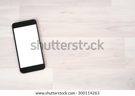 Smartphone on wooden table on light background Royalty-Free Stock Photo #300114263