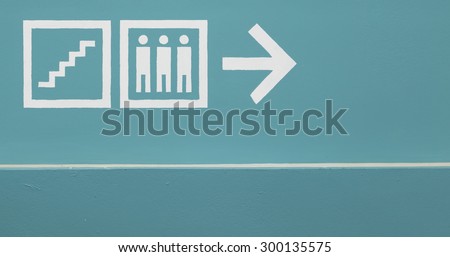 Direction to elevator and stairs on green wall